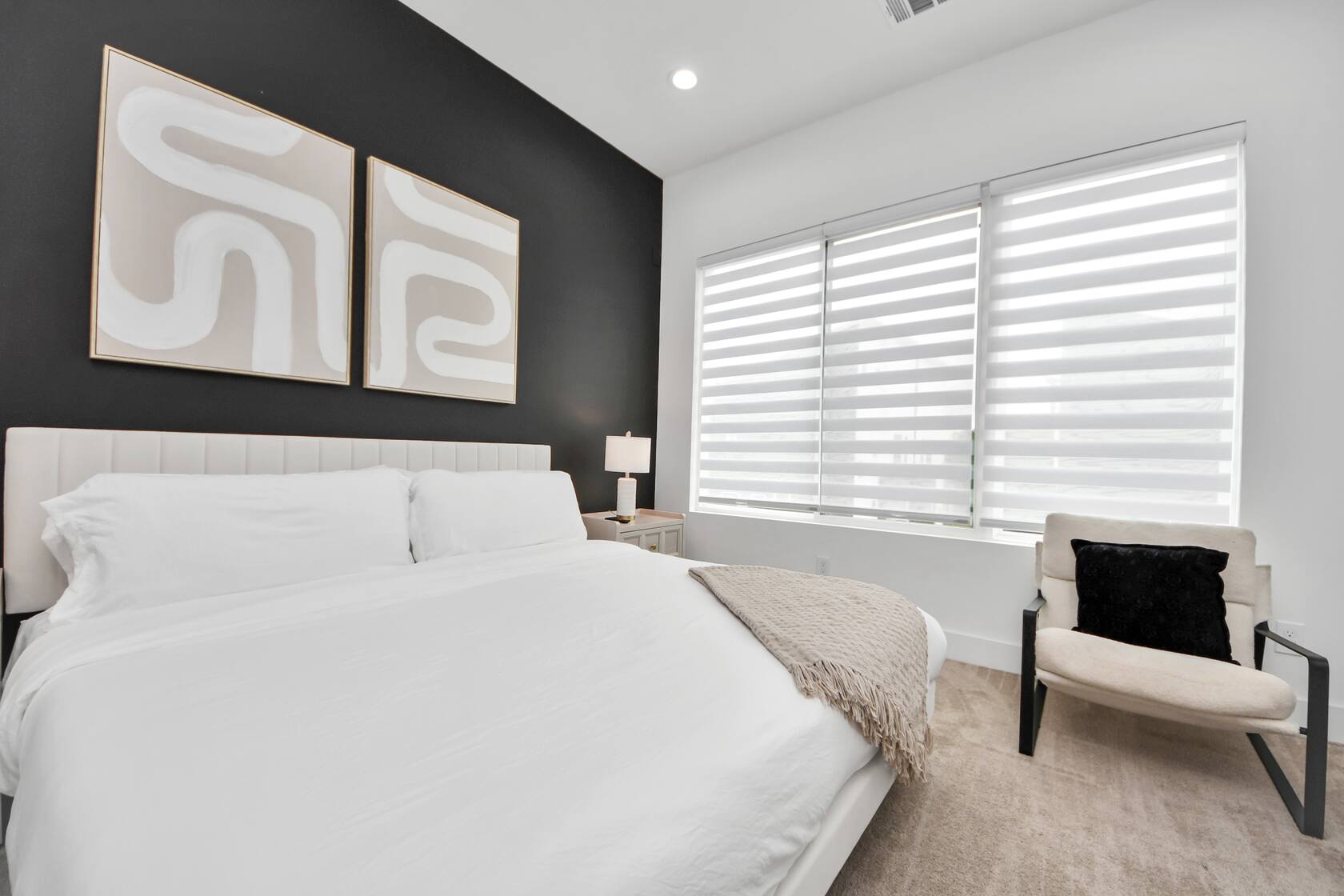 Second bedroom with crisp white linens against a dark accent wall