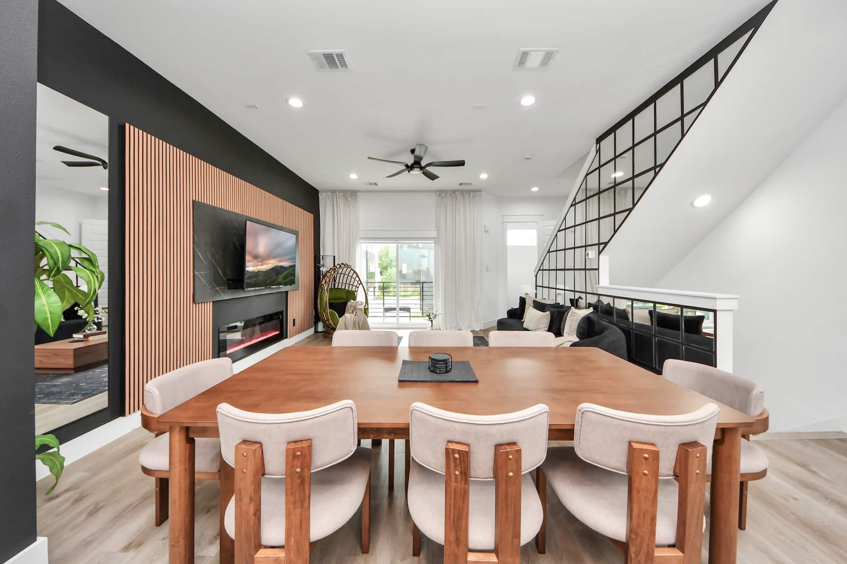 Dining area with a long wooden table looking toward the living room